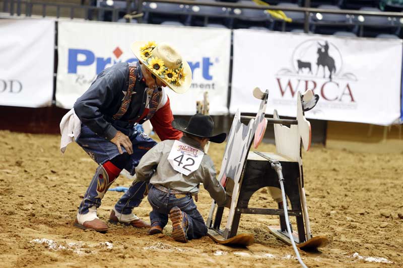 2015 marked the last year of Pokey the Clown’s World Championship Junior Ranch Rodeo, where pee-wees, juniors and senior youths got the chance to learn about ranching heritage while competing in events with stick horses and wooden cows. Here, Pokey, aka Doug Smith, teaches a young cowboy how to milk one of the wild cows.