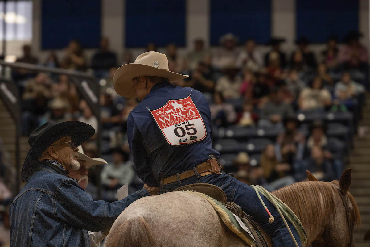 Logan Delinte, riding a horse, shaking the hand of Gary Morton